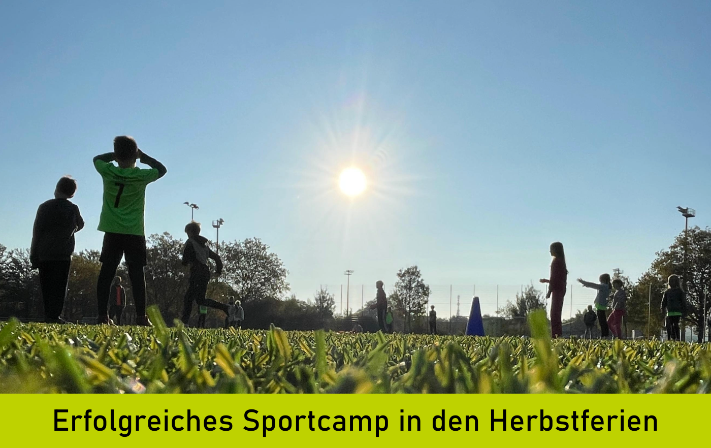 Sportplatz mit Kindern im Herbst, die Sonne steht tief.