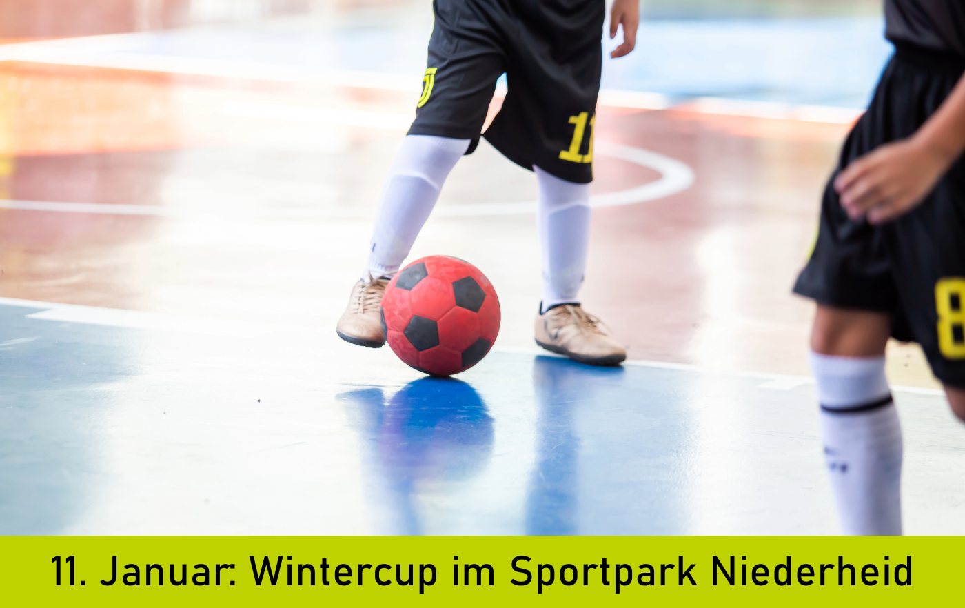 Beine von Fußball spielenden Kindern mit Ball